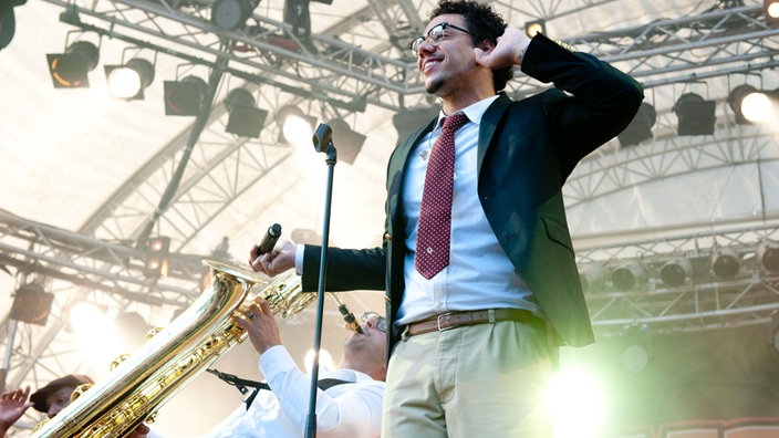 Ben L'Oncle Soul hebt die Hand an sein Ohr um zu signalisieren, dass er das Publikum nicht hört
