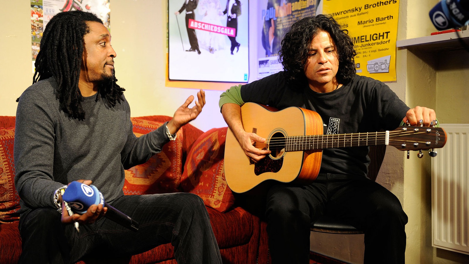 Die Band The I.M.F's hinter der Bühne mit ARD Mikrofon und Akustikgitarre
