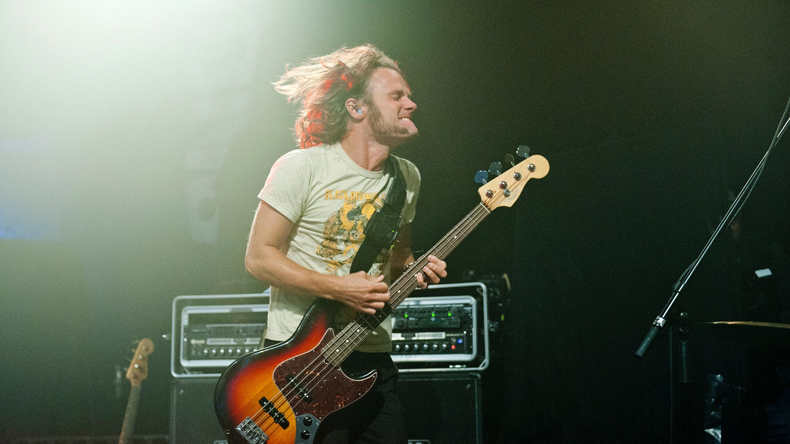 Der Sänger spielt mit ordentlich Power seine Gitarre, die Haare fliegen umher.