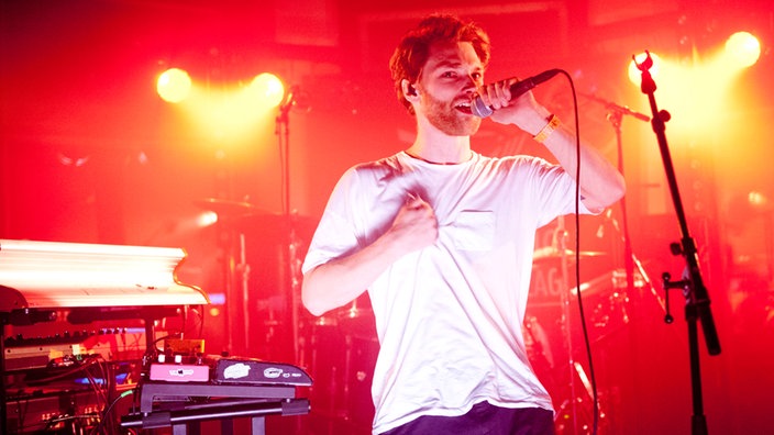 Frontman während eines Songs - er krallt seine Faust in sein T-Shirt.