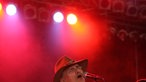 Dickey Betts singt und wird von roten Scheinwerfern angestrahlt