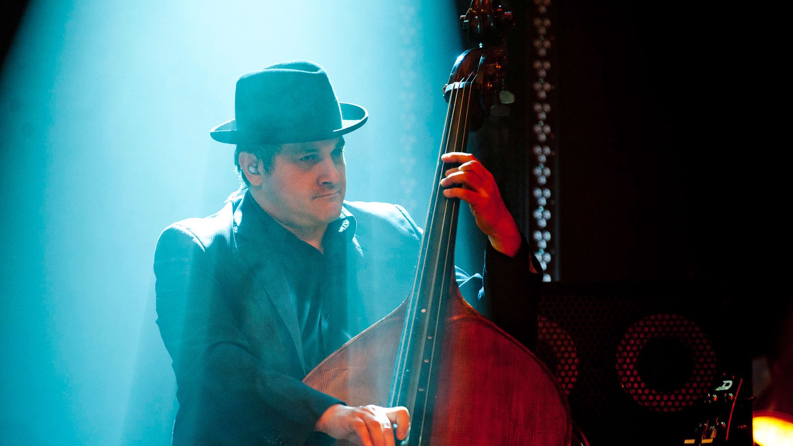 Ein Mann mit Hut spielt Kontrabass und wird blau ang
