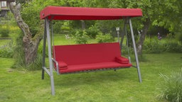 Das Bild zeigt eine Hollyswoodschaukel in Rot in einem Garten.
