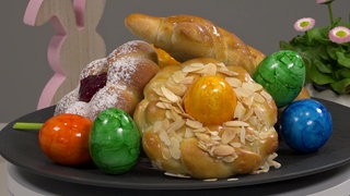 Das Bild zeigt verschiedene Hefeteilchen mit Osterdekoration auf einem Teller.
