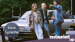 Bild mit "klare Sprache"-Logo: Schimanski mit Thanner und "Hänschen" am Auto