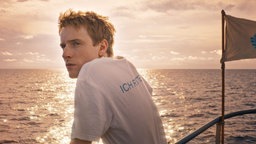 Louis Hofmann steht an der Reling eines Schiffes