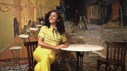 Siham El-Maimouni sitzt an einem Kaffehaustisch