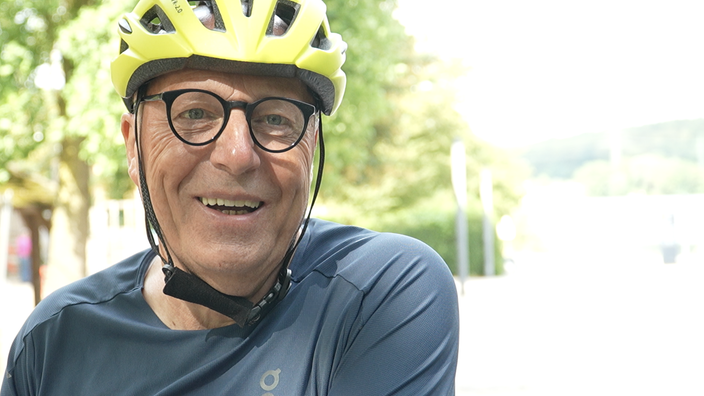 Radfahrer Matthias Hilgenbrink im Gespräch mit gelbem Fahrradhelm auf dem Kopf 