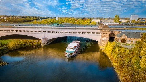 Ein Ausflugsschiff fährt auf der Weser in Minden unter dem Mittellandkanal durch.