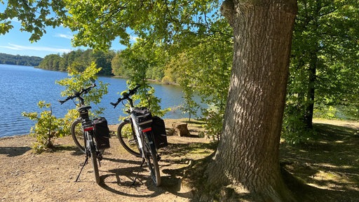Zwei Fahrräder stehen vor dem Möhnesee.