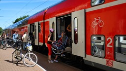 Bahnfahrer steigen mit Fahrrad in die Bahn