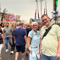 Claudia und Leo Becker stehen zwischen vielen Menschen und Buden mitten auf der Cranger Kirmes.