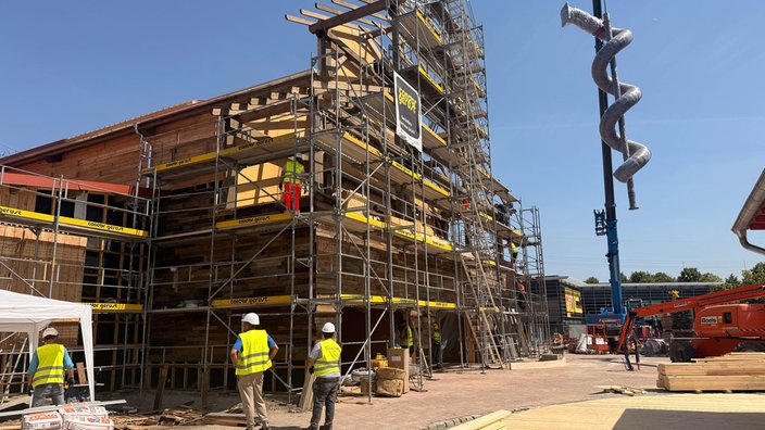 Auf der Baustelle des Freizeitparks Karls Erlebnisdort wird ein Gebäude gebaut und die große Röhrenrutsche montiert.