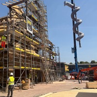 Auf der Baustelle des Freizeitparks Karls Erlebnisdort wird ein Gebäude gebaut und die große Röhrenrutsche montiert.