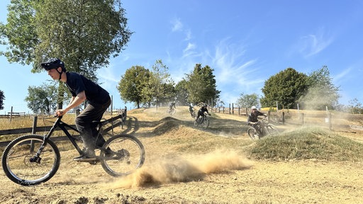 Mountainbiker fahren staubige Trailpiste hinunter
