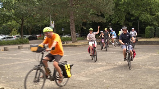 Eine Gruppe Radfahrende startet mit Tourenguide vom ADFC auf die Strecke