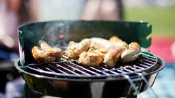 Das Bild zeigt einen Grill mit Fleisch.