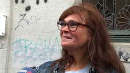 Mittelalte Frau mit braunen Haaren und einer braunen Brille
