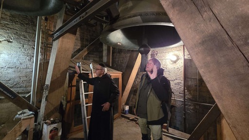 Bruder Leonhard Poot und Geologe Sven von Loga an der Glocke "Regina Coeli" in der Abteikirche in Maria Laach.