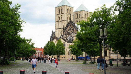 Der Domplatz in Münster mit grünen Bäumen.