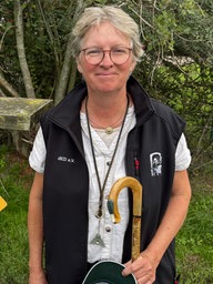 Die Schäferin Sandra Bremicker steht neben einem Schild, auf dem "Sheep Area" steht