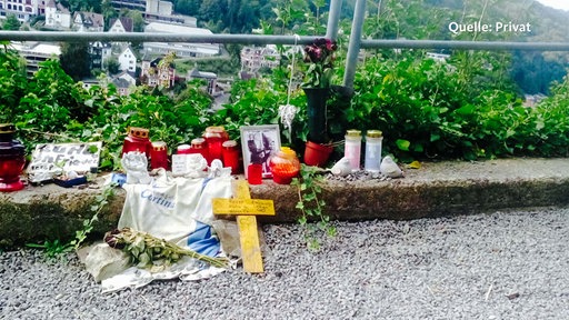 Kerzen, Blumen und Bilder an einem Geländer bei Burg Altena.