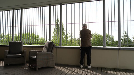 Ein Mann steht in einer Einrichtung der forensischen Psychiatrie