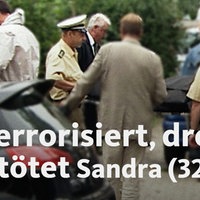 Polizisten stehen auf der Straße zwischen Autos und unterhalten sich.