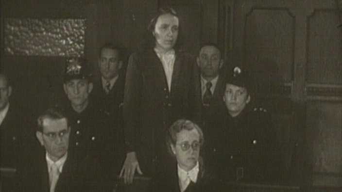 Schwarz-weiß-Aufnahme von Irmgard S. beim Prozess gegen sie vor dem Kölner Landgericht, sie steht auf der Anklagebank