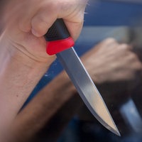 Eine Hand hält ein Messer und macht damit eine Stichbewegung