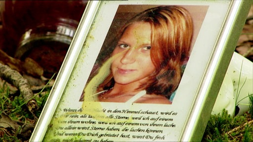 Ein gerahmtes Foto von Frauke Liebs liegt am Fundort ihrer Leiche in einem Waldstück