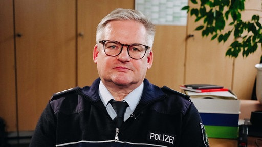 Kriminalpolizist Stefan Weiand, ein Mann mit kurzen grauen Haaren und Brille, sitzt in einem Büro.