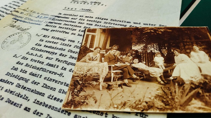 Ein orange-gelbes Familienfoto liegt auf einem Schriftdokument
