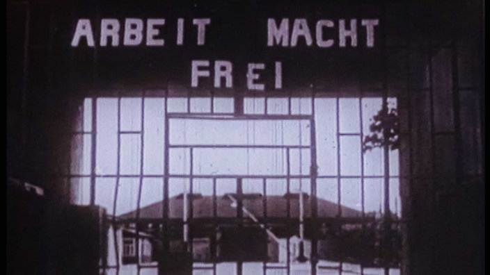 Schwarz-Weiß-Aufnahme von einem Eingangstor, darüber steht "Arbeit macht frei"