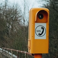 Eine orangene SOS-Säule auf der Autobahn.