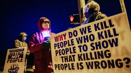 Demonstrierende gegen die Hinrichtung von Lisa Montgomery und zwei weiteren Personen im US-Bundesstaat Indiana. "Why do we kill people who kill people to show that killing people is wrong?" steht auf einem Plakat.
