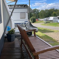 Ein Bild von einem Wohnmobil mit einer Bank auf dem Campingplatz Vier Jahreszeiten. 