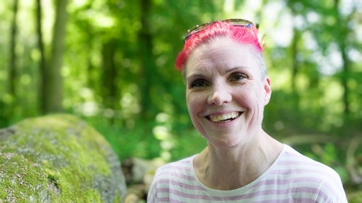 Frau lacht in die Kamera