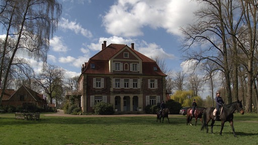 Drei Jugendliche reiten vom Hof.