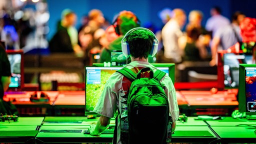 Besucher spielen bei der Gamescom am Computer