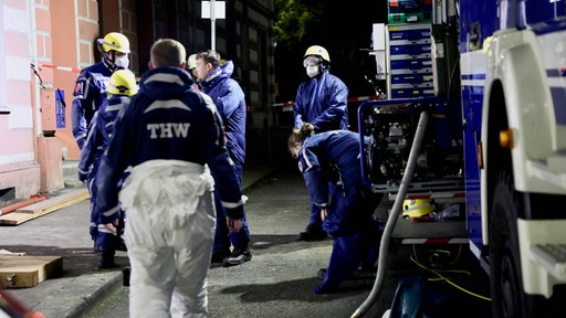 Einsatzkräfte und ein Einsatzfahrzeug in Ausrüstung vor einem Gebäude in Wuppertal