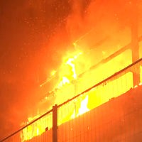 Meterhohe Flammen und eine große Rauchwolke auf einem Recyclinghof