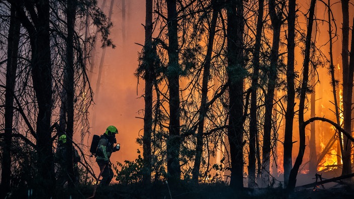 Feuerwehrleute kämpfen gegen die Flammen und Glutnester