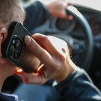 Ein Mann telefoniert in seinem Auto mit einem Smartphone