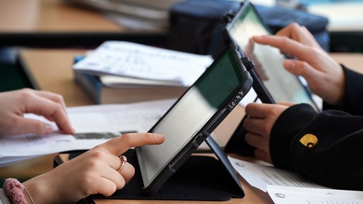 Kinder bedienen Tablets im Unterricht