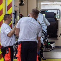 Rettungssanitäter heben eine Patientin aus dem Rettungswagen