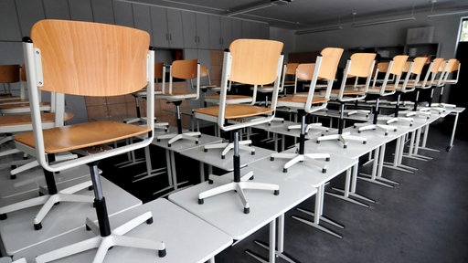 Ein Klassenraum mit den Stühlen auf den Tischen 