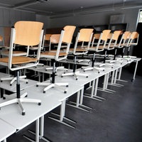 Ein Klassenraum mit den Stühlen auf den Tischen 
