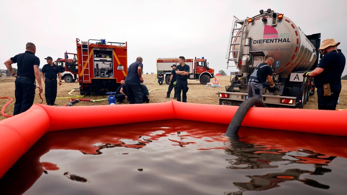 Bauern und Helfer bringen immer wieder neue Wassertanks heran.
