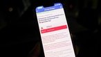 Auf einem Mobiltelefon wird die offizielle Entwarnung durch Nina-Warnapp für die Ortschaft Hürtgenwald-Gey angezeigt.